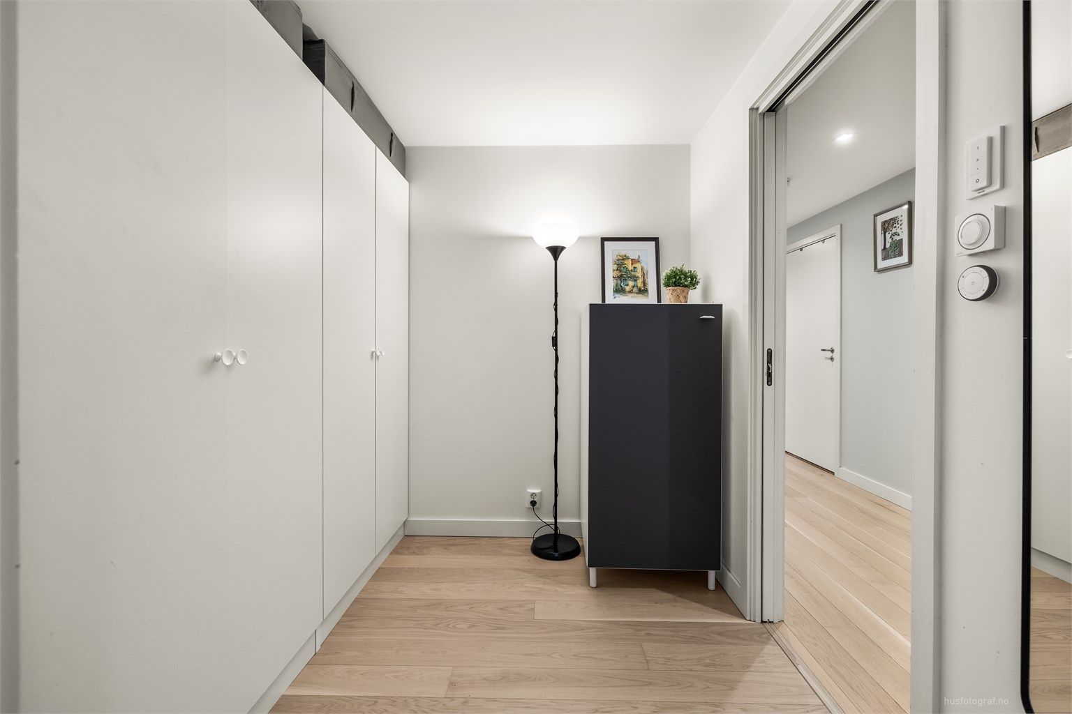 Omkledningsrom med parkett på gulv, malte vegger og malt himling