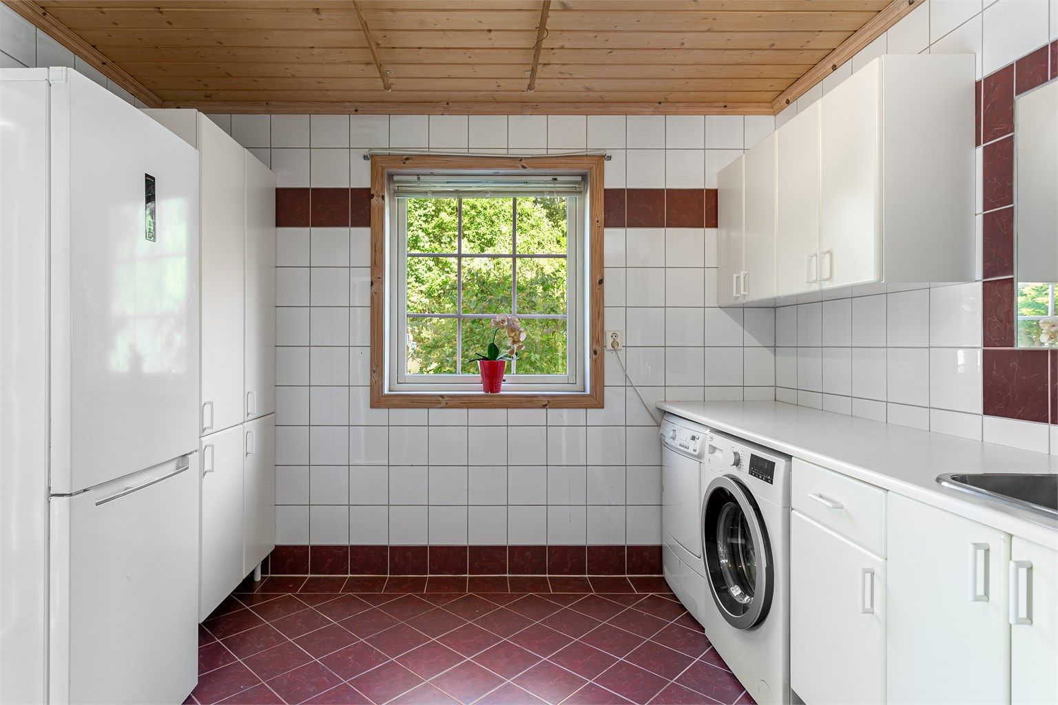Separat vaskerom med skapinnredning og egen utgang til terrassen.