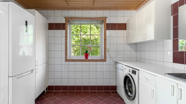 Separat vaskerom med skapinnredning og egen utgang til terrassen.