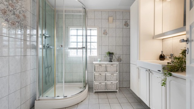 Bad med flislagt gulv med varme og flislagte vegger.