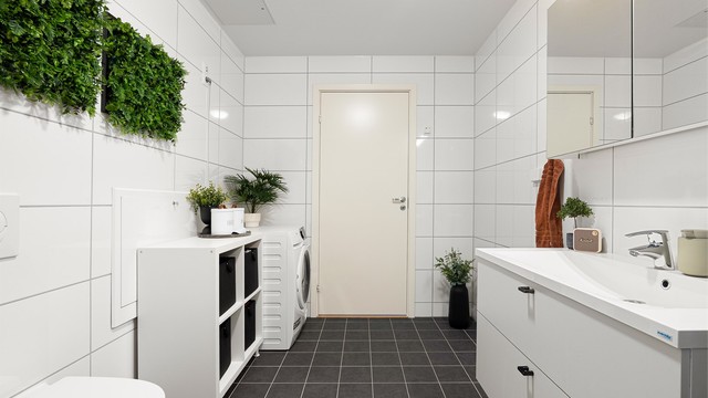 Badets romslige 8 kvm. er praktisk til kombinert bruk som vaskerom. Vaskemaskinen har lett tilgjengelig plass i hjørnet ved døren.