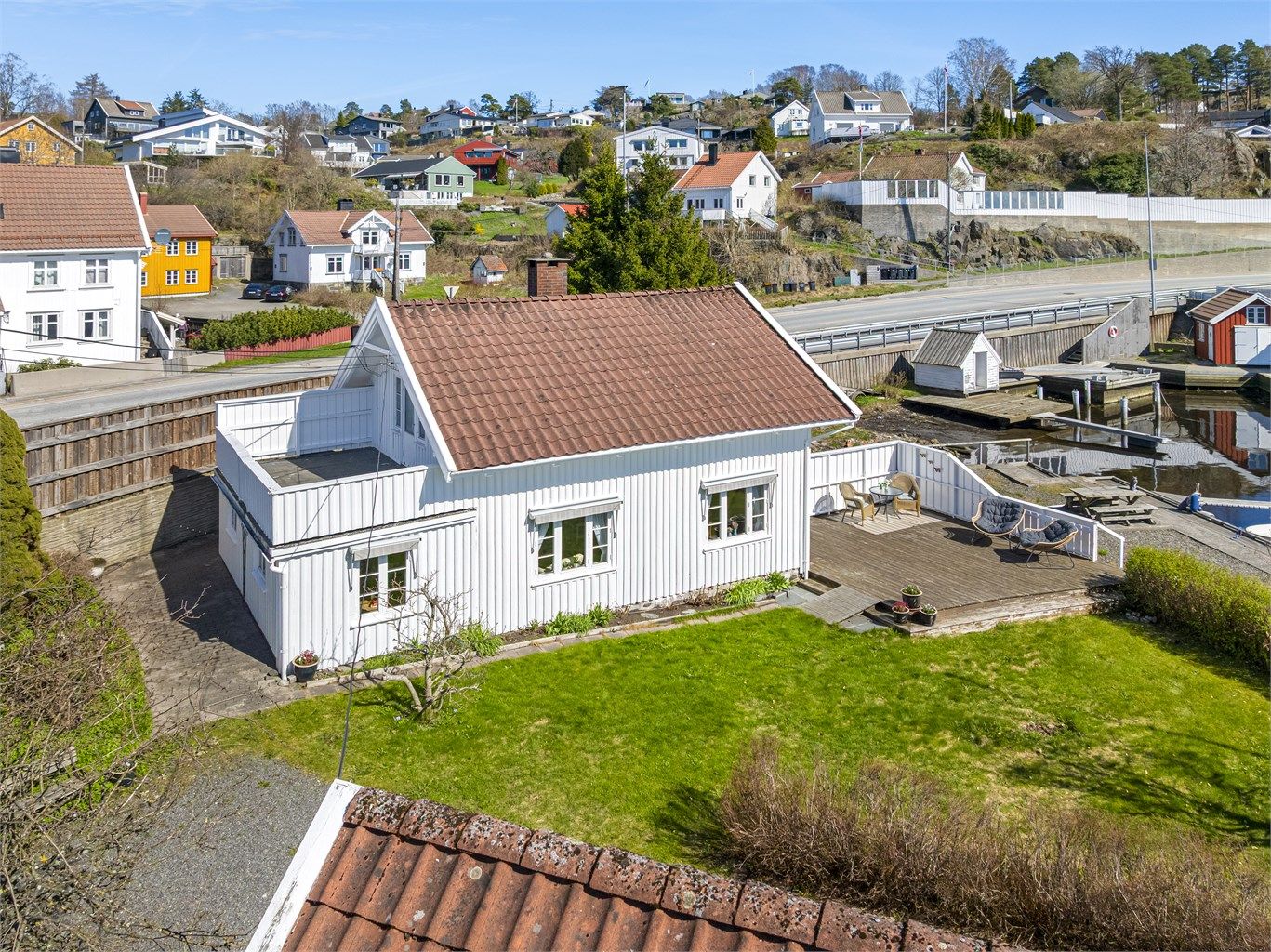 Eiendommen er skjermet fra veien med høy skillevegg. 