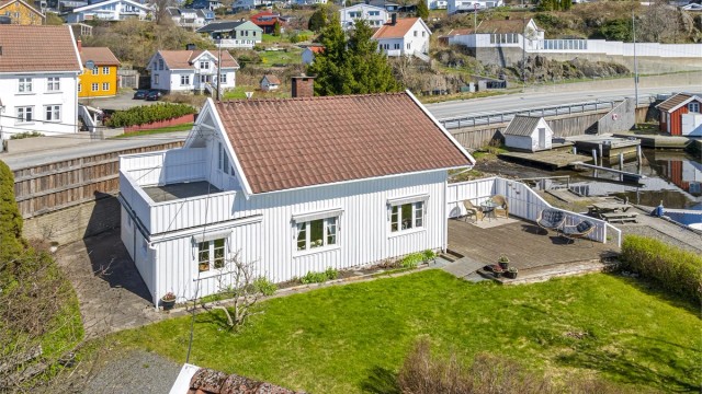 Eiendommen er skjermet fra veien med høy skillevegg.