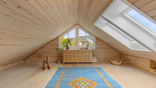 Innredet loftstue med heltre furugulv, takvinduer og gavlvindu som slipper inn rikelig med lys.