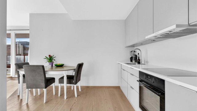 Kjøkken med integrerte hvitevarer som koketopp, stekeovn, kjøl-/fryseskap og oppvaskmaskin