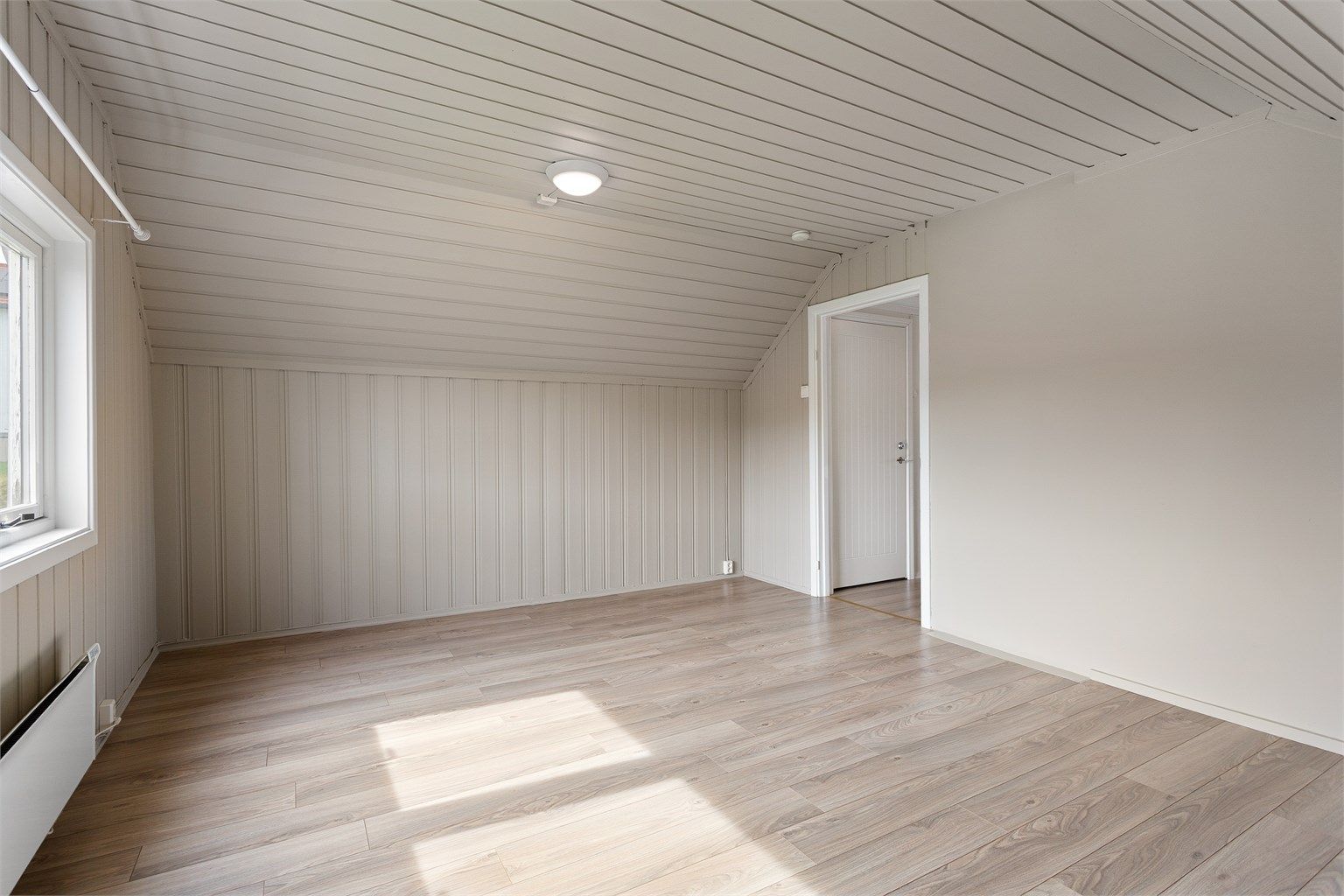 Takhøyden i stuen varierer fra 0,71 til 2,29 meter, noe som gir rommet en karakteristisk loftsfølelse.