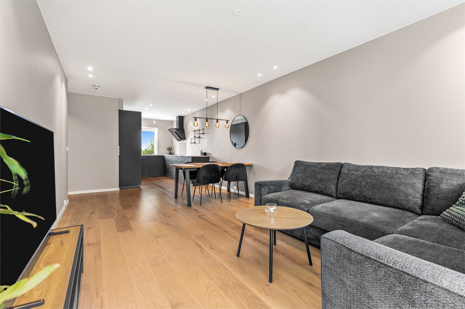 Lys og åpen stue med åpen løsning mot kjøkkenet. Stuen gir en god romfølelse med naturlig flyt mellom sonene.