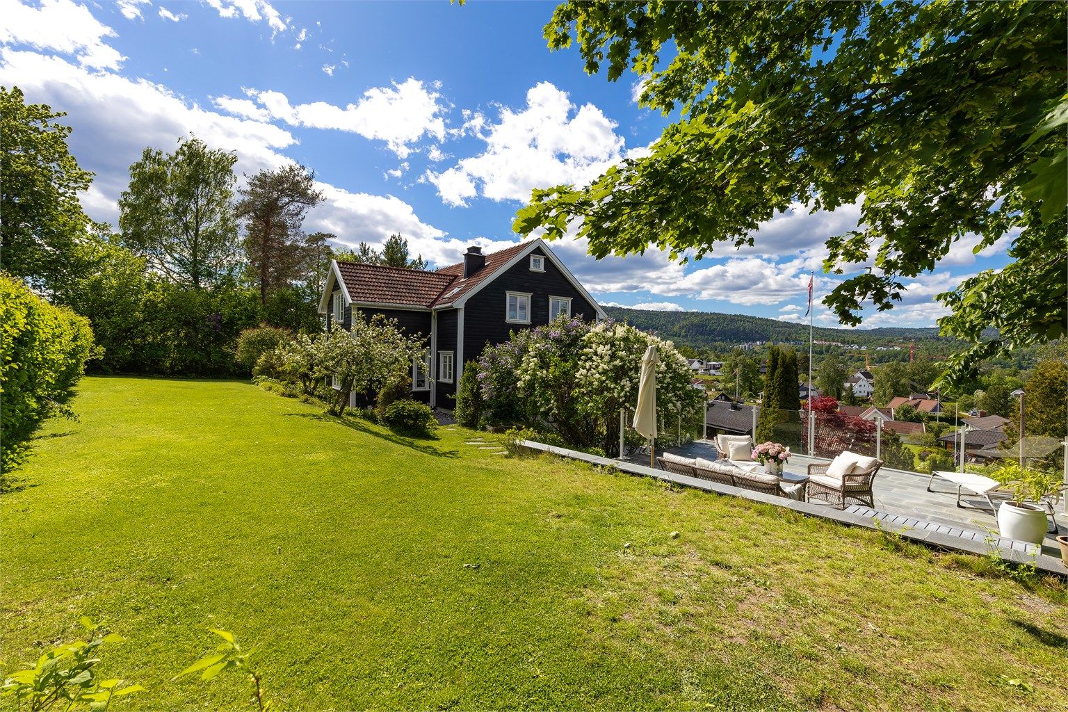 Huset er plassert slik at det er omkranset av enten gressplen eller steinlagt/asfaltert gårdsplass. Her bor du flott, både sentralt, skjermet og med mye lys fra alle kanter.