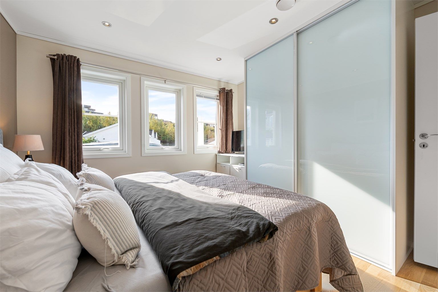 Romslig skyvedørsgarderobe med glassfronter gir gode oppbevaringsmuligheter.