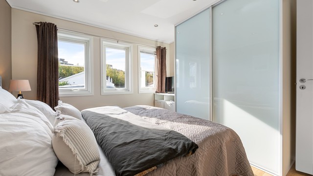Romslig skyvedørsgarderobe med glassfronter gir gode oppbevaringsmuligheter.