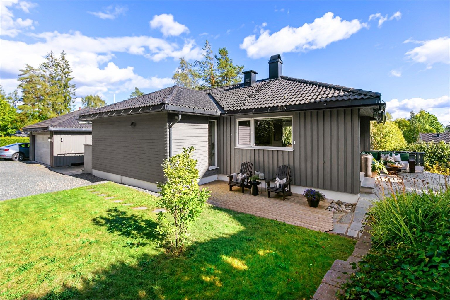 Eiendommen har sammenhengende uteplasser på flere nivåer rundt boligen.