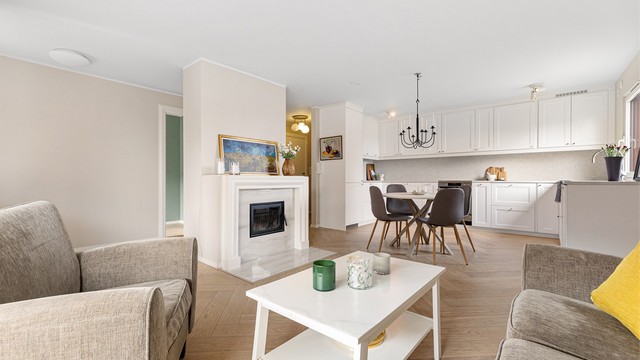 Den åpne løsningen mellom stue og kjøkken skaper en lys og sosial sone, med god plass til både sofagruppe og spisebord.