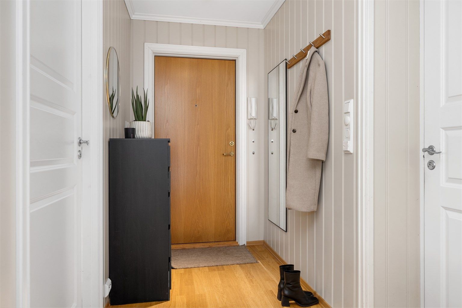 Velkommen inn i en romslig entré med gode oppbevaringsmuligheter og plass til oppheng av yttertøy og sko.