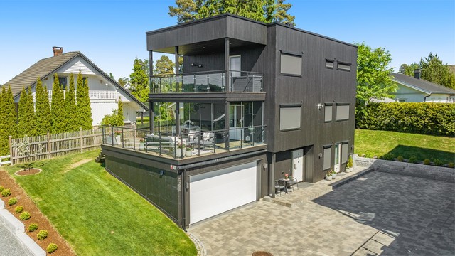 Enebolig fra 2021 med integrert dobbelgarasje, balansert ventilasjon og flere store uteplasser. Legg merke til solskjermingen.