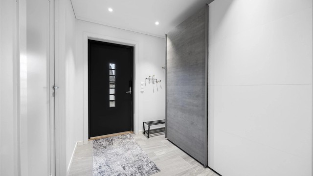 Entré med flislagt gulv, gulvvarme og skyvedørsgarderobe.