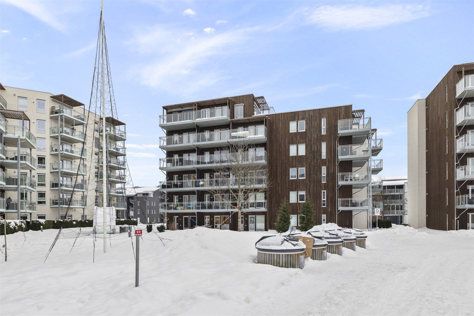 Bygget har en moderne fasade med en kombinasjon av teglstein og trepanel.