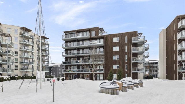 Bygget har en moderne fasade med en kombinasjon av teglstein og trepanel.