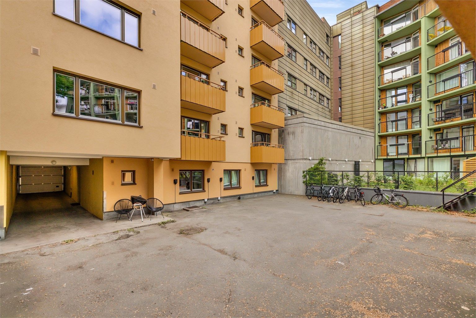 Felles tomt er opparbeidet med asfalterte fellesarealer, sykkelparkering og en bakgård med søppelkasser. 