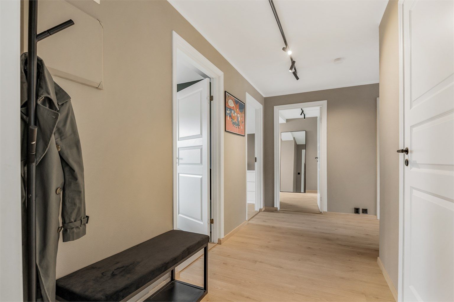 Leiligheten ønsker deg velkommen med en hyggelig entrè malt i morderne farger