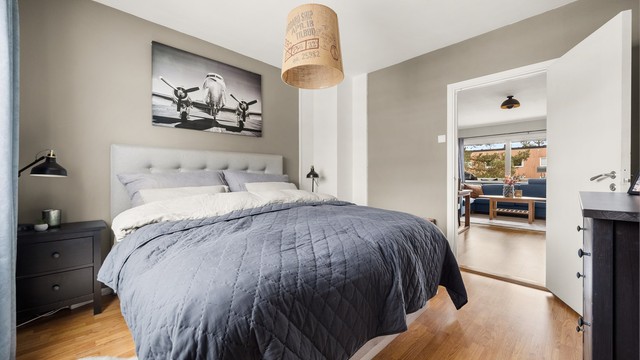 Et lunt og behagelig rom med malte flater og parkett på gulvet.