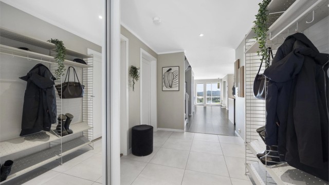 Fra entreen åpner boligen seg opp mot den sosiale sonen med stue og kjøkken.