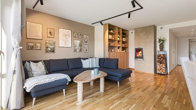 Stuen er utstyrt med en integrert peis med glassdør og 3-stavs eikeparkett.
