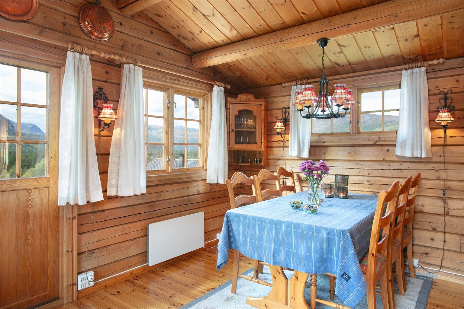 Spiseplassen er plassert ved vinduet med utsikt mot fjellandskapet.