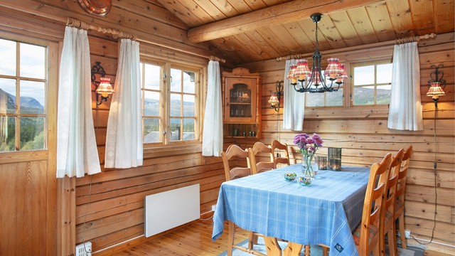 Spiseplassen er plassert ved vinduet med utsikt mot fjellandskapet.