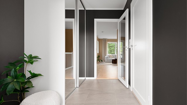Innbydende entré med flislagt gulv og varmekabler. Dør med glassfelt slipper lyset videre inn.
