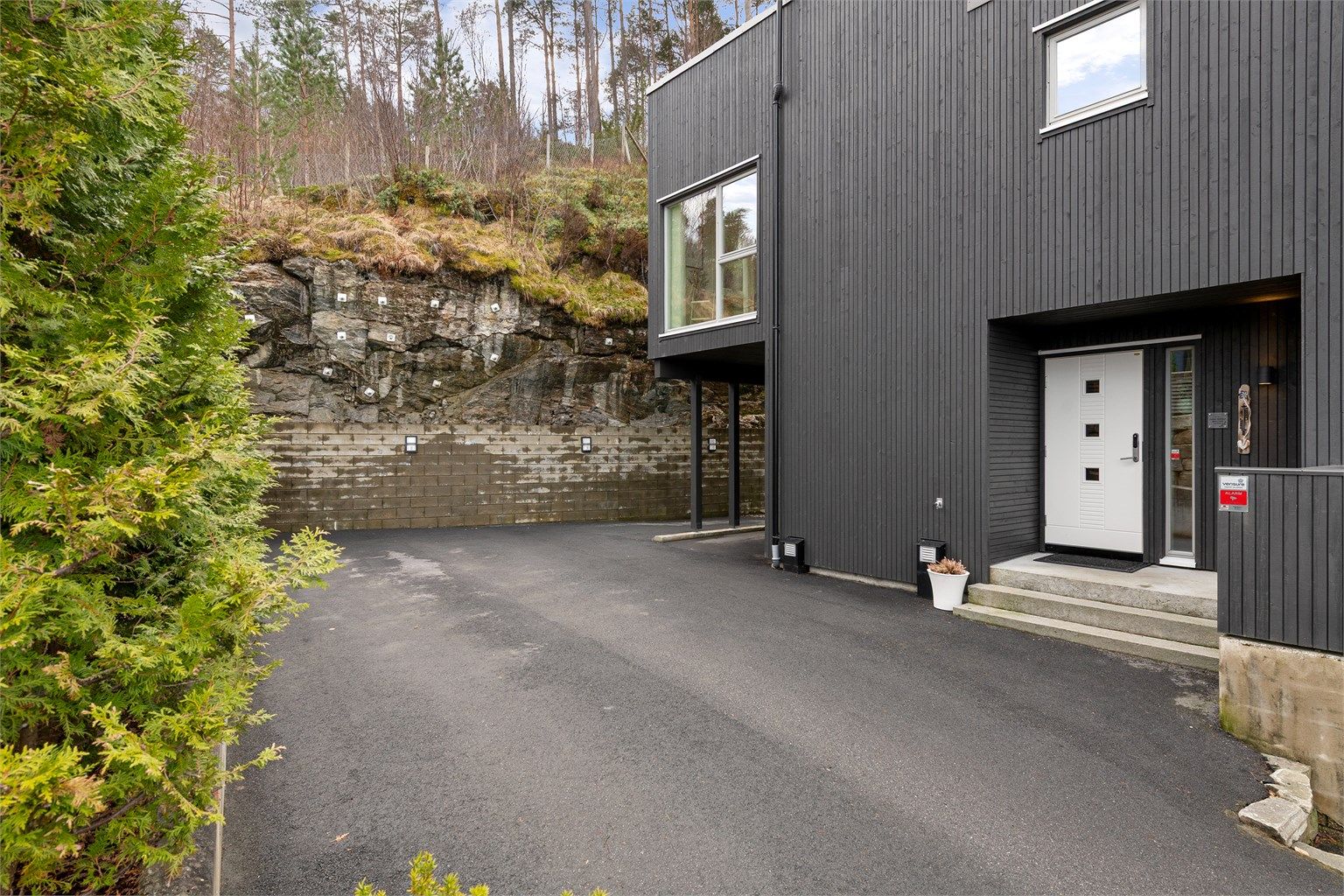 Asfaltert gårdsplass med gode parkeringsmuligheter, inkludert en carport med mulighet for elbillader