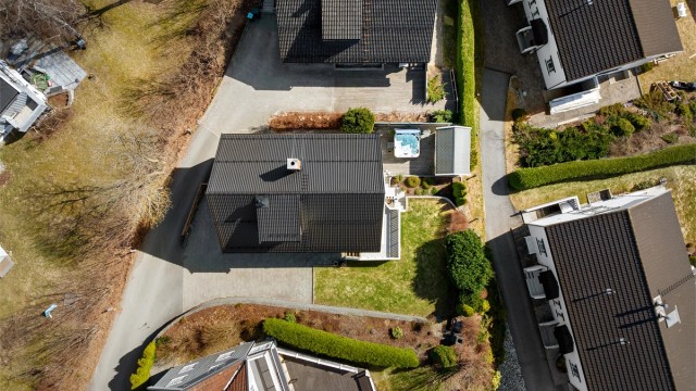 Tomten er opparbeidet med innkjørsel, plenarealer og flere uteplasser.