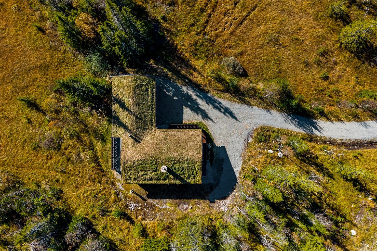 Hytta er kledd med torvtak som glir naturlig inn i landskapet.