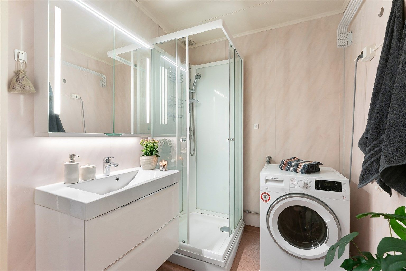 Badet har dusjkabinett, servantinnredning fra 2018 og opplegg for vaskemaskin.