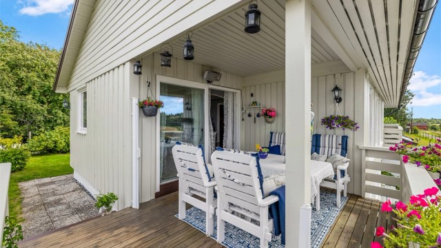 Uteplassen er belagt med terrassebord og har rekkverk i tre.