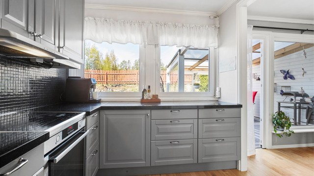 Kjøkkenet har vindu mot uteområdet og utgang til den overbygde delen av terrassen.