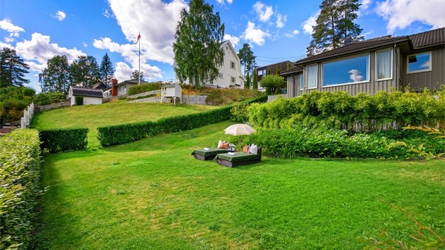 Skjermet hage med gressplen og god plass til lek og utendørsaktiviteter.