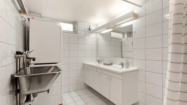 Badet i kjelleren er utstyrt med dobbel servant, utslagsvask og opplegg for vaskemaskin.