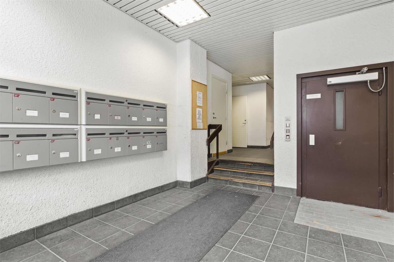 Inngangsparti til bygården / fellesareal med postkasser, heis m.m