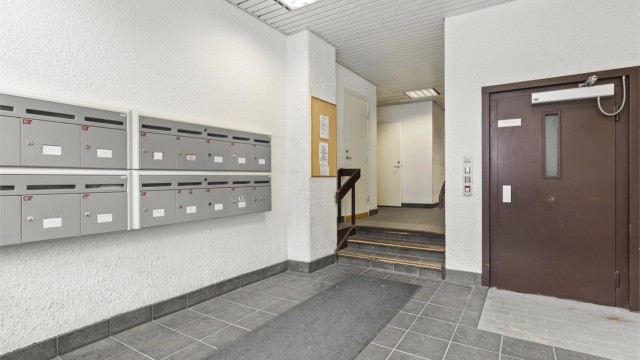 Inngangsparti til bygården / fellesareal med postkasser, heis m.m