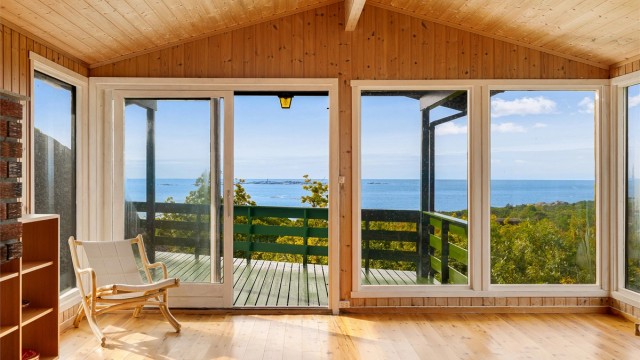 Luftig og innbydende stue med store vindusflater som slipper inn rikelig med naturlig lys og byr på fantastisk panoramautsikt over fjorden.
