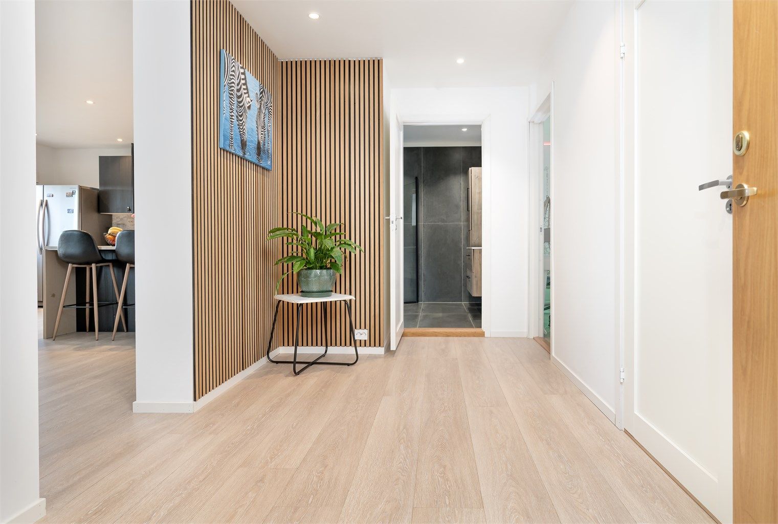 En vegg med spilepanel i gangen gir et moderne og lunt preg.