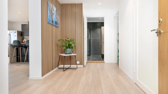 En vegg med spilepanel i gangen gir et moderne og lunt preg.