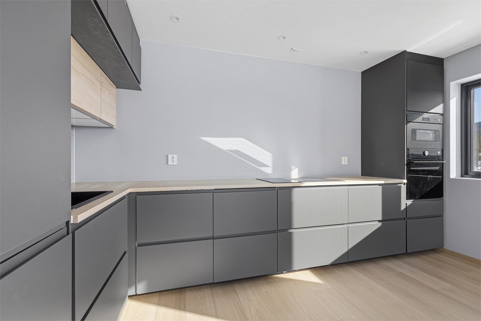 Kjøkkenet har tradisjonell L-form og godt med skap-og skuffeplass samt integrerte hvitevarer.