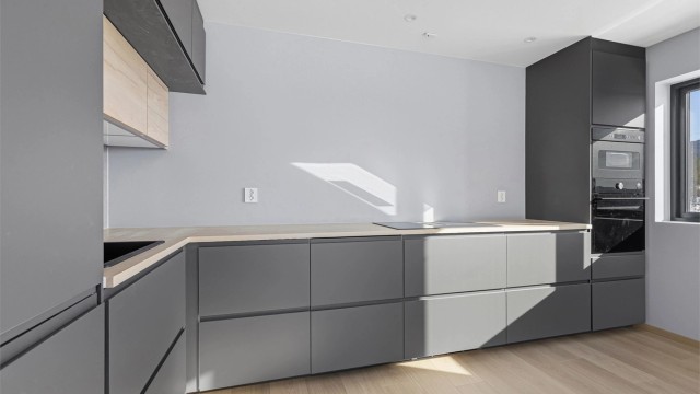 Kjøkkenet har tradisjonell L-form og godt med skap-og skuffeplass samt integrerte hvitevarer.