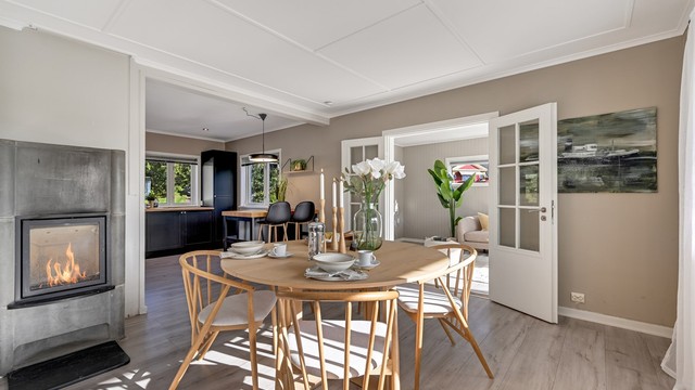 Her er det god plass til både spisegruppe og sofakrok, samtidig som vedovnen skaper en lun og hyggelig atmosfære gjennom årets kjøligere måneder