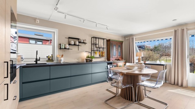 Stilrent og moderne kjøkken fra Drømmekjøkkenet, installert i 2024, er sømløst integrert i den åpne planløsningen.