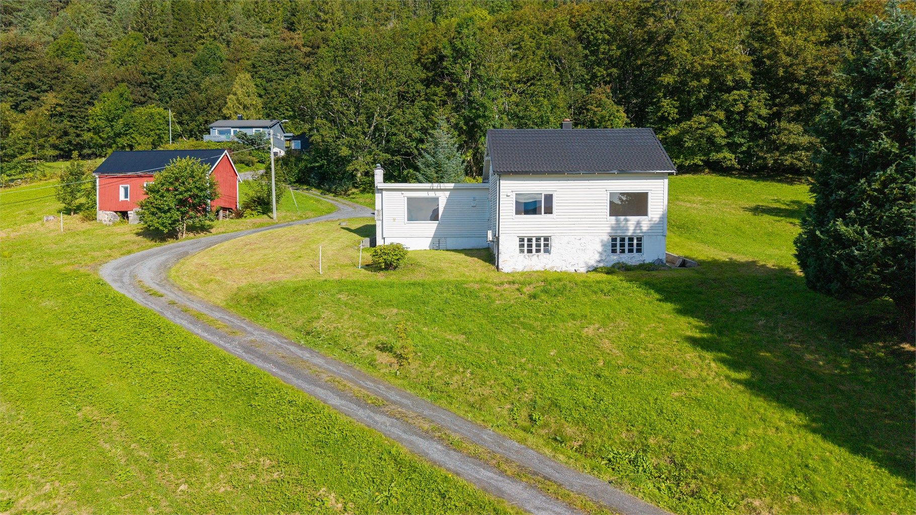 Gruset adkomstvei fører opp til tunet foran boligen.