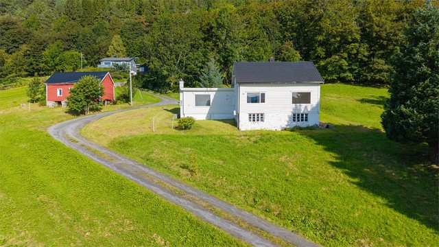 Gruset adkomstvei fører opp til tunet foran boligen.