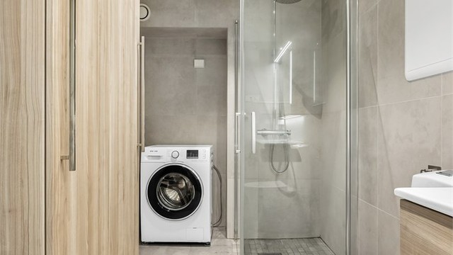 Badet er funksjonelt innredet med opplegg for vaskemaskin og god skapplass.