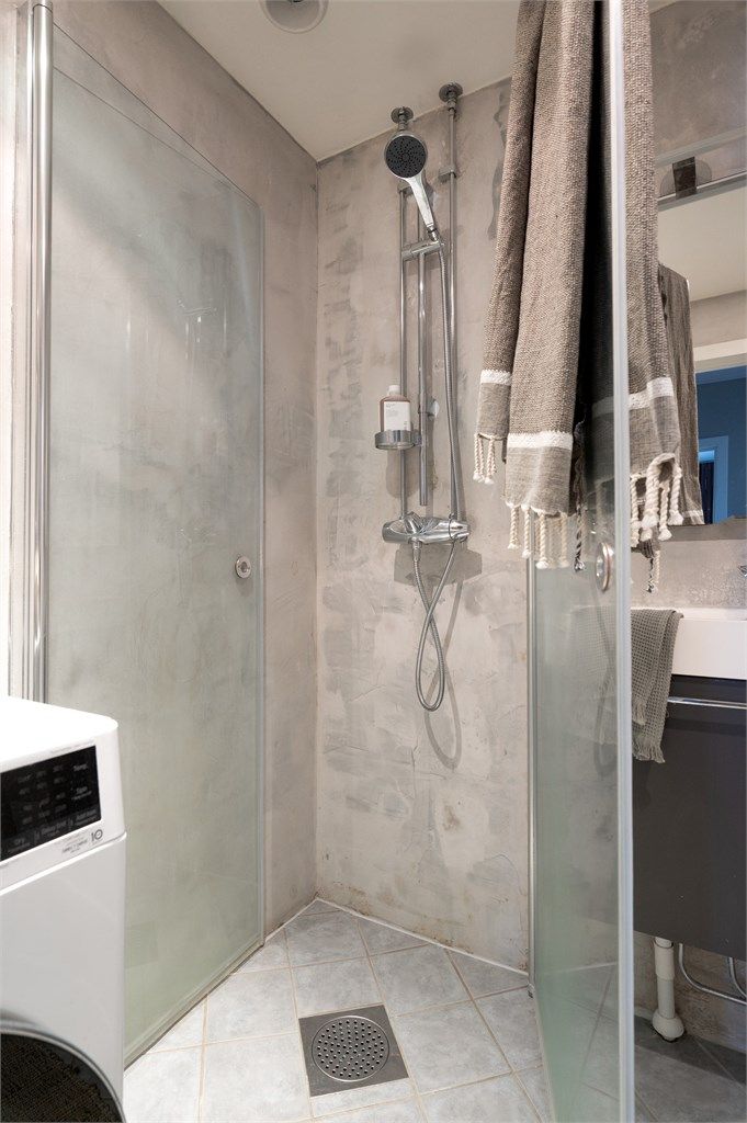 Dusjhjørnet har praktiske, innfellbare glassvegger. Det er også opplegg for vaskemaskin.